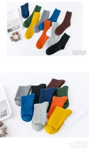 Flat lay of colorful cotton ribbed socks in navy, green, and orange on white background