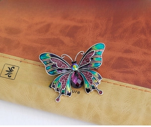 Detail of vintage enamel butterfly brooch with purple teardrop gemstone and crystals
