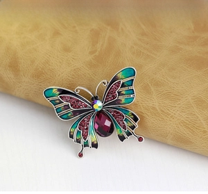 Detail of butterfly brooch with purple water-drop crystal and colorful enamel inlay