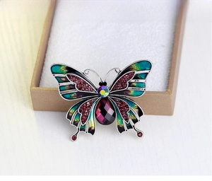Detailed macro of vintage butterfly brooch with pink rhinestones and purple gem