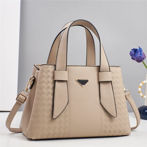Détail du sac à main beige en cuir grainé avec motif losange embossé et garniture dorée