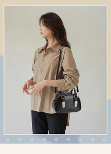 Detail of elegant black PU leather crossbody bag with vintage golden metal buckle decoration