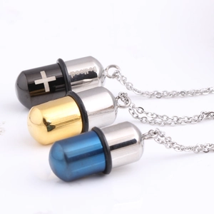 Capsule pendant necklaces in black, gold, and blue stainless steel with cross detail