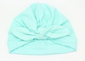 Detailed view of soft mint green knit baby turban hat with a large decorative bow