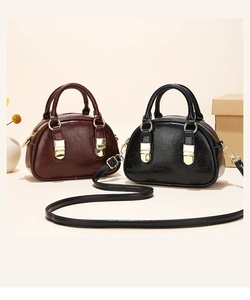 Detail of vintage shell-shaped mini bags in burgundy and black with glossy oil wax finish