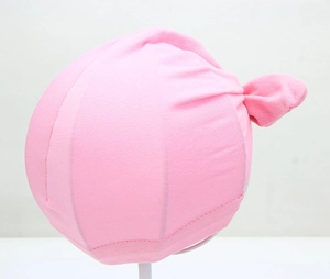 Detail view of pink cotton baby turban hat showing the soft knit fabric and side knot design