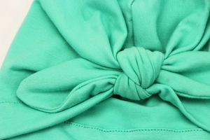 Detail of mint green soft cotton knit baby turban hat with knot and fine stitching