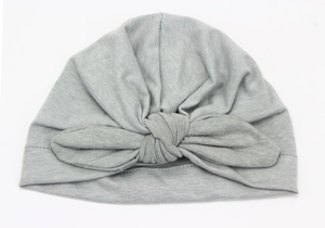Detail of light gray baby turban hat showing soft knit texture and large bow knot