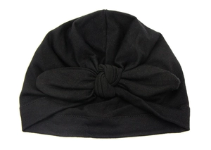 Detail of a soft black baby turban hat featuring a large decorative bow and knot design