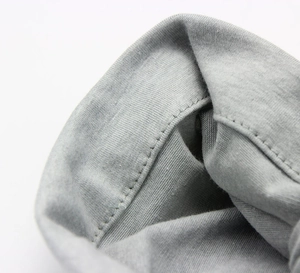 Macro shot of precise stitching and soft knit texture on a light gray baby turban hat