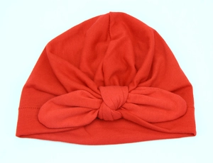 Detailed view of soft red cotton baby turban hat with a large decorative bow