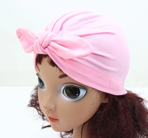 Detail of pink bow knot turban hat for infants with pleated elastic fabric texture