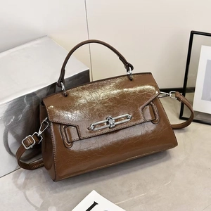 Detailed macro of brown oil-wax leather texture and silver buckle on a stylish handbag