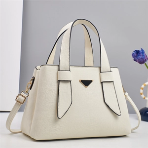 Elegant cream leather handbag with triangular metal plaque and versatile shoulder strap
