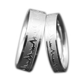 Detail view of silver stainless steel rings featuring black walnut inlay and heartbeat engraving