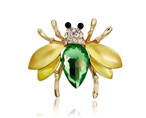 Macro shot of a bee brooch featuring a pear-cut green gemstone and yellow wings