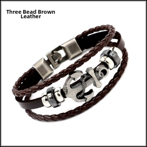 Detail of multi-layer braided brown leather bracelet with silver anchor and beads