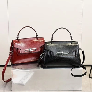 Detail of vintage glossy crossbody bags in dark red and black with silver hardware