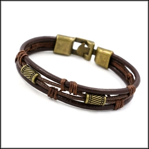Detailed view of multilayer brown braided leather bracelet with bronze metal clasp