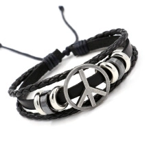 Detail of multi-layer black leather bracelet with silver peace sign charm and adjustable cord
