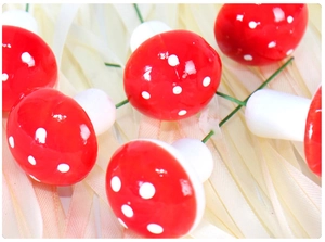 Detailed close-up of mini red and white polka dot Christmas mushrooms with wire stems