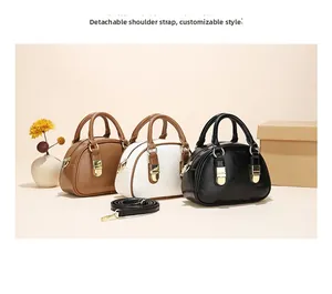 Detail of crossbody bag with detachable shoulder strap and metallic zipper closure