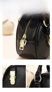 Detail of smooth golden metal zippers and stitching on a black textured bowling bag