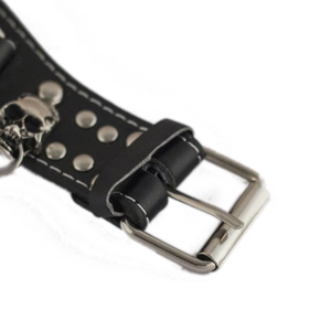 Close-up of black punk leather strap featuring metal skull and silver rivet details