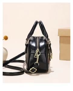 Detail of black glossy mini Boston bag with gold hardware and removable shoulder strap