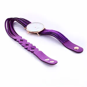 Detailed view of women's purple wrap watch with floral charms and sparkly crystals