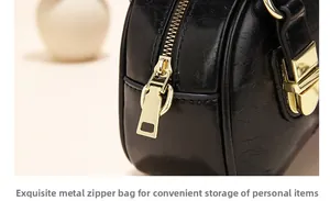 Macro shot of glossy black wax leather texture and golden zipper detail on shoulder bag