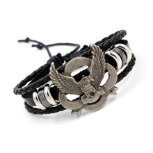 Detail of hand-woven black leather bracelet featuring a bronze eagle charm and drawstrings