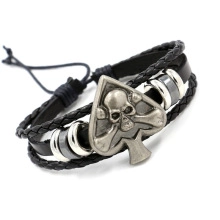 Detailed close-up of handmade black braided leather bracelet with silver skull spade charm