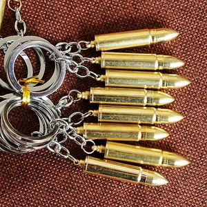 Detailed view of bullet-shaped metal keychains in gold and silver finish on fabric