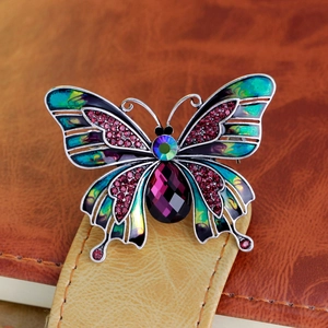 Vintage enamel butterfly brooch with purple crystals on a leather background