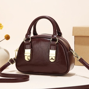 Retro wine red shell crossbody bag with polished texture and golden hardware accents