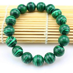 Macro detail of malachite bead bracelet showing natural green striped texture and luster