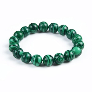 Macro shot of malachite beaded bracelet showing natural green circular grain and texture
