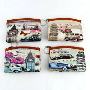 Detail view of four vintage coin purses featuring Eiffel Tower prints and zipper keychains