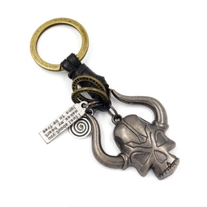 Detail of vintage metal elk skull charm and engraved plate on braided leather keychain