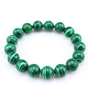 Macro shot of green malachite beaded bracelet showing natural striped patterns