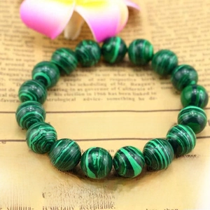 Close-up of 10mm synthetic malachite beaded bracelet with unique green striped patterns