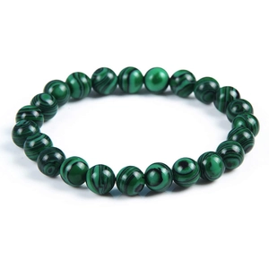 Macro detail of polished green malachite beaded bracelet showing natural black wavy textures