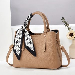 Brown litchi grain leather handbag with a houndstooth scarf and golden hardware details