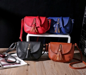 Detailed view of saddle crossbody bags in four colors with long tassels and zip rings