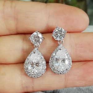 Macro shot of silver teardrop earrings with pear-cut cubic zirconia and pavé halo detail