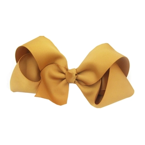 Close-up of a 15cm golden grosgrain ribbon hair bow for babies with high quality texture