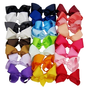 Detail showing 15cm oversized satin bow hair clips in multiple vibrant colors on white background