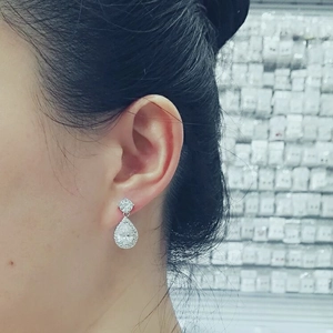 Close-up of elegant silver teardrop zirconia earrings worn by a model in a side view
