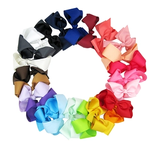 Macro shot of 15cm large fabric hair bows in various colors arranged in a circle